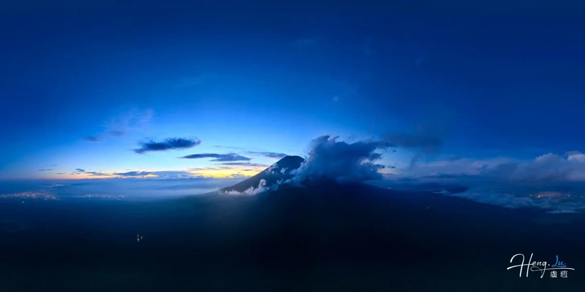 Mountain peak rising above clouds at dawn